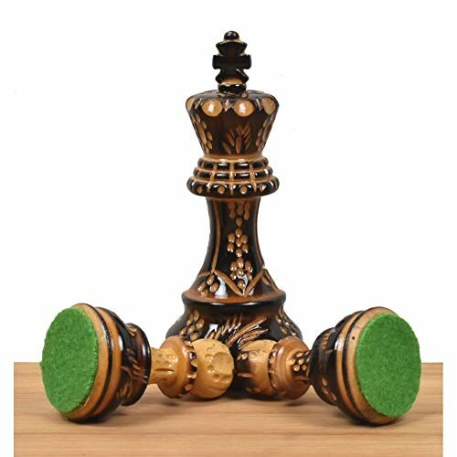 Ornate chess king and fallen pieces on a wooden board